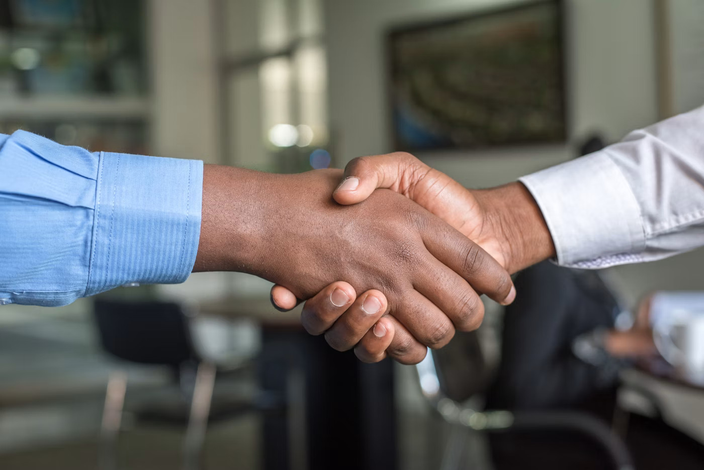 Business professionals shaking hands during a contract-to-hire staffing meeting
